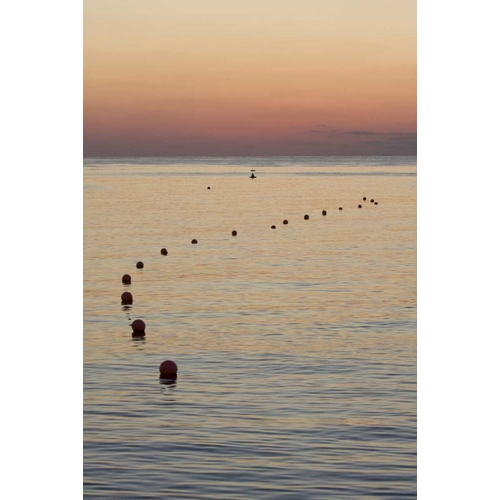 UAE, Fujairah Sunrise over marker buoys on beach